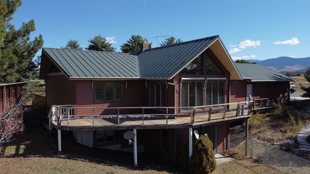 rear view of property with a deck with mountain view