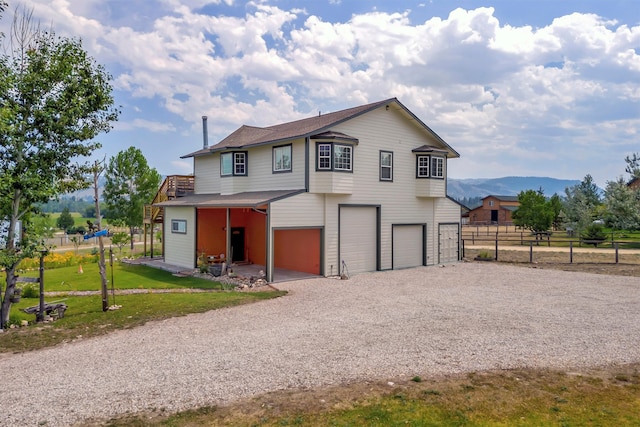 view of front of home featuring a garage, a front lawn, and a mountain view