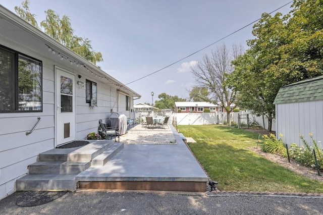 view of yard with a storage shed and a patio area