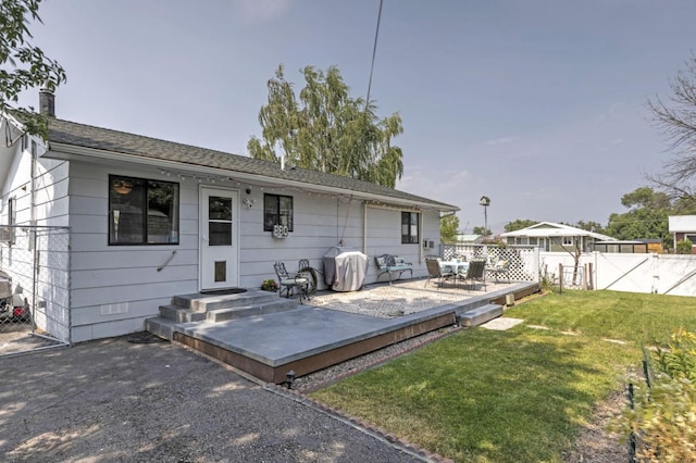 rear view of property featuring a patio area and a lawn