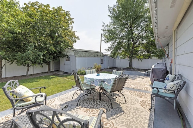 view of patio with area for grilling and a shed