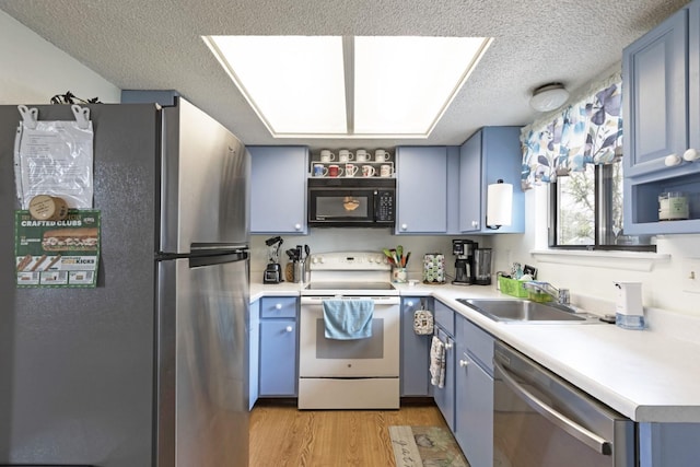 kitchen featuring sink, stainless steel appliances, blue cabinetry, a textured ceiling, and light hardwood / wood-style flooring