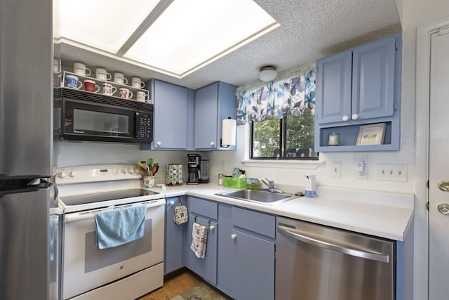 kitchen with appliances with stainless steel finishes, blue cabinets, sink, and a textured ceiling