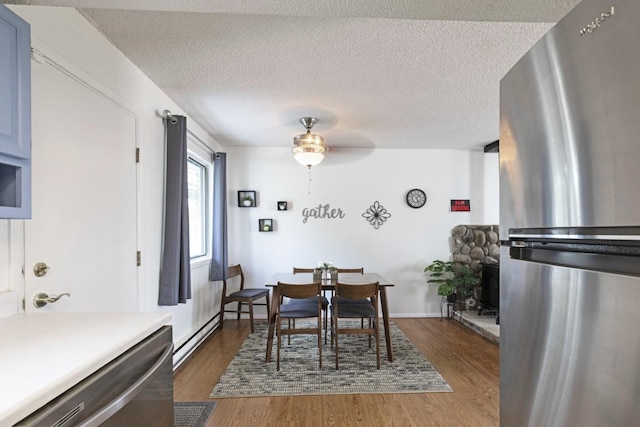 dining area with ceiling fan, dark hardwood / wood-style floors, and a textured ceiling