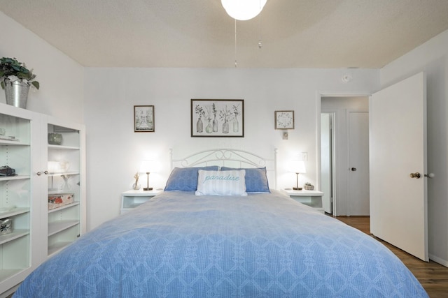 bedroom featuring dark hardwood / wood-style floors and a textured ceiling