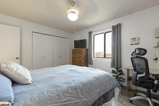 bedroom featuring hardwood / wood-style flooring, ceiling fan, a closet, and a textured ceiling