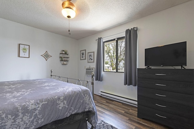 bedroom with dark wood-type flooring, a textured ceiling, a wall unit AC, ceiling fan, and a baseboard heating unit