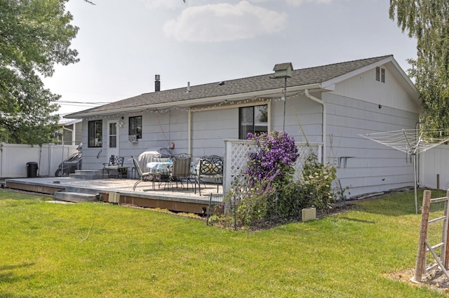 rear view of house with a deck and a lawn