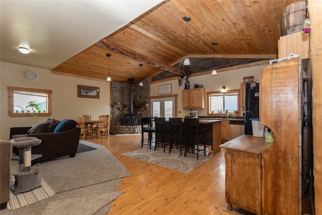 dining area featuring vaulted ceiling, wooden ceiling, plenty of natural light, and light hardwood / wood-style floors