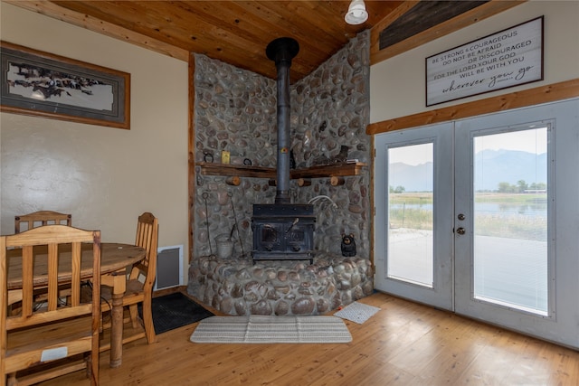 living room with a wood stove, light hardwood / wood-style flooring, french doors, and wood ceiling