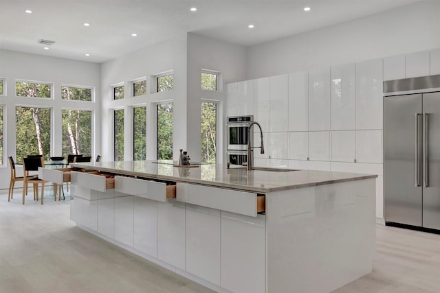 kitchen with a large island, white cabinets, and appliances with stainless steel finishes