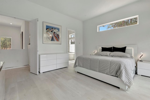 bedroom featuring light hardwood / wood-style floors and ensuite bathroom