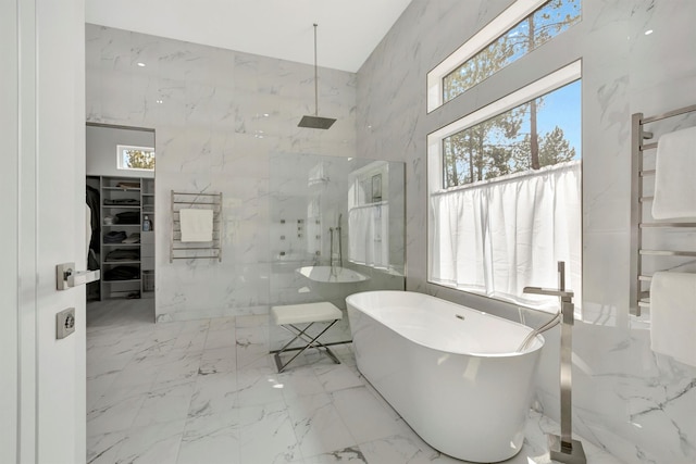 bathroom with tile walls and independent shower and bath