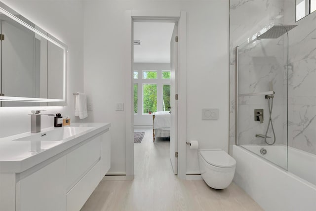 full bathroom featuring bath / shower combo with glass door, vanity, and toilet