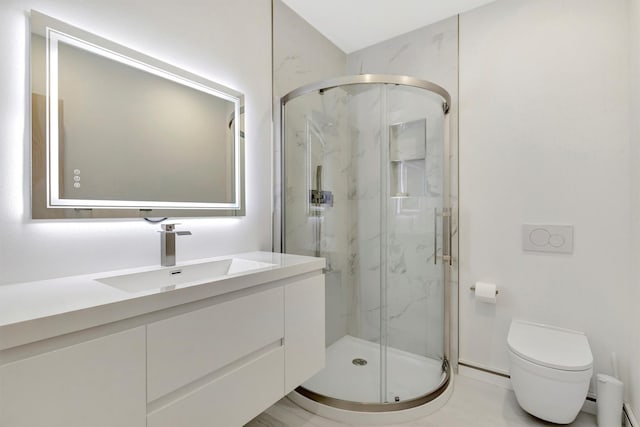 bathroom featuring vanity, a shower with shower door, and toilet