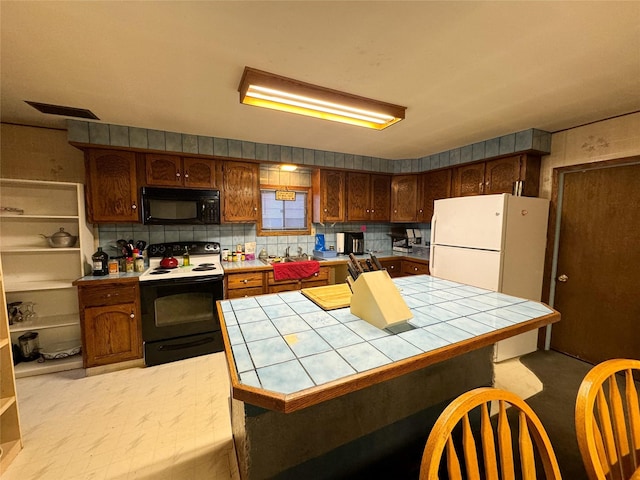 kitchen featuring electric stove, tile counters, white fridge, and backsplash