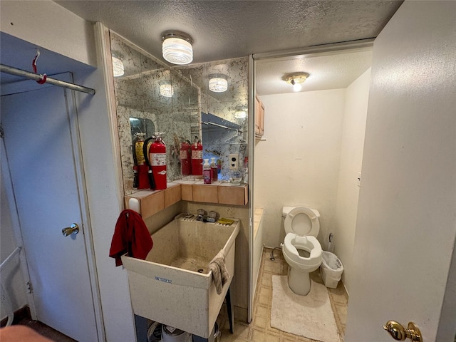 bathroom featuring sink, toilet, and a textured ceiling