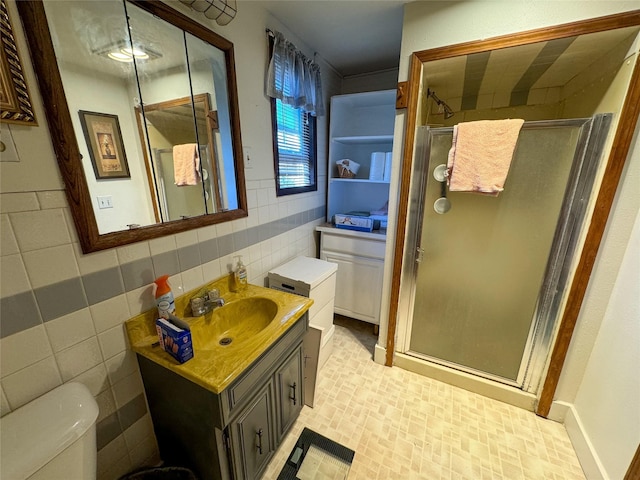 bathroom with walk in shower, vanity, toilet, and tile walls