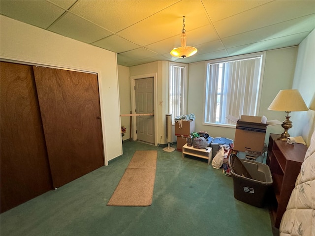 interior space with a drop ceiling and dark carpet