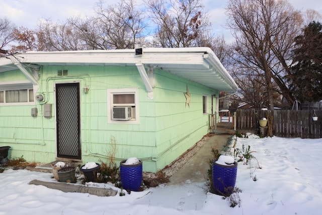 view of snow covered exterior with cooling unit