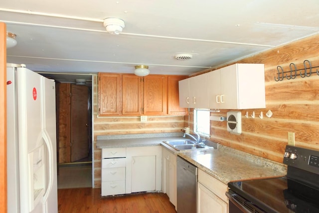 kitchen featuring white fridge with ice dispenser, dishwasher, wooden walls, sink, and electric range