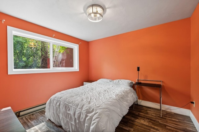 bedroom with baseboards, wood finished floors, and baseboard heating