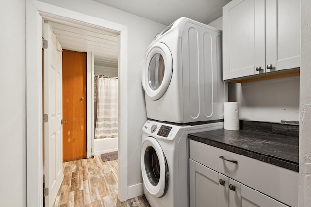 1520 W Lakeshore Dr, Whitefish, MT 59937 - laundry room featuring estacked washer and dryer, light wood-style flooring, and cabinet space