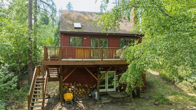 rear view of house featuring stairs, roof with shingles, french doors, and a wooden deck