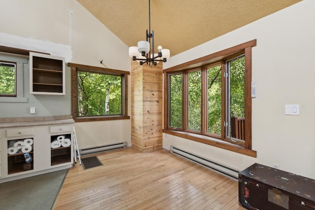 1520 W Lakeshore Dr, Whitefish, MT 59937 - unfurnished dining area with a baseboard heating unit, a chandelier, plenty of natural light, vaulted ceiling, and a textured ceiling