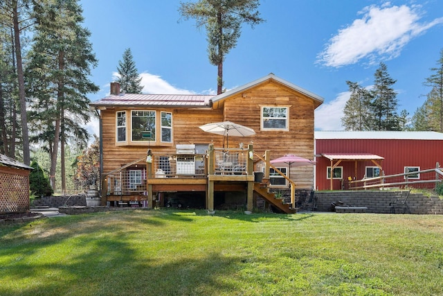 back of property with a chimney, a lawn, metal roof, a deck, and stairs