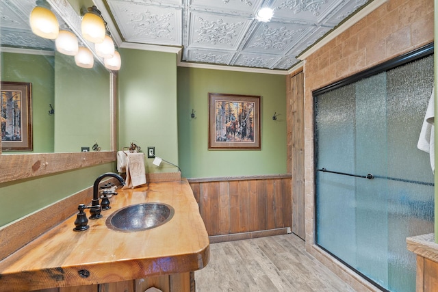 635 Lore Lake Rd, Kalispell, MT 59901 - bathroom with a wainscoted wall, wood finished floors, a sink, ornamental molding, and an ornate ceiling