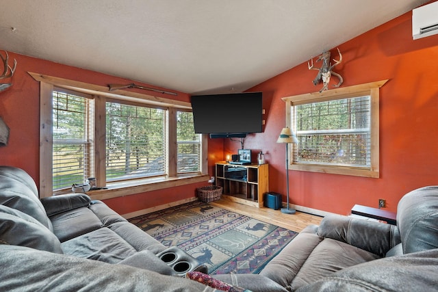635 Lore Lake Rd, Kalispell, MT 59901 - living room with lofted ceiling, an AC wall unit, wood finished floors, and baseboards