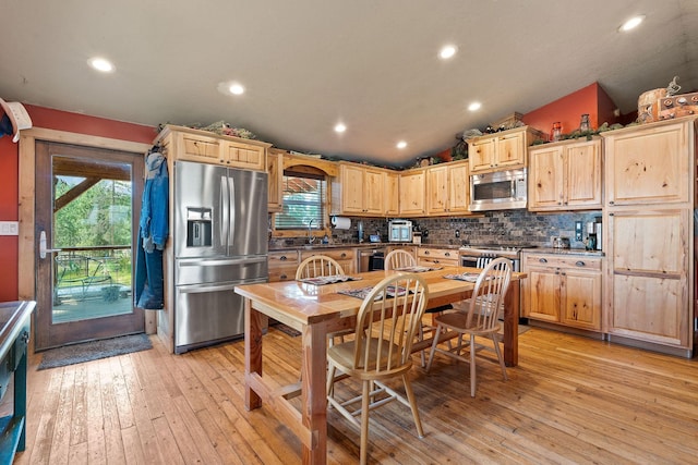 635 Lore Lake Rd, Kalispell, MT 59901 - kitchen featuring stainless steel appliances, vaulted ceiling, decorative backsplash, and light brown cabinetry