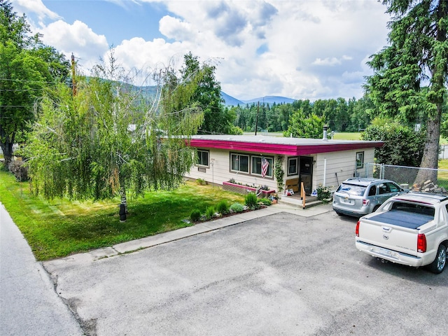 view of front of home featuring a mountain view, a front yard, and a porch