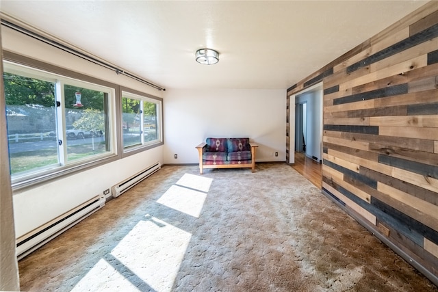 spare room with baseboard heating and wooden walls