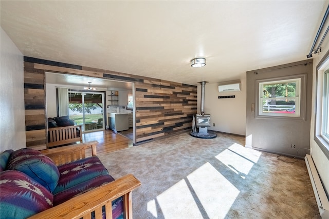 carpeted living room with baseboard heating, a wood stove, wooden walls, and a wall mounted air conditioner