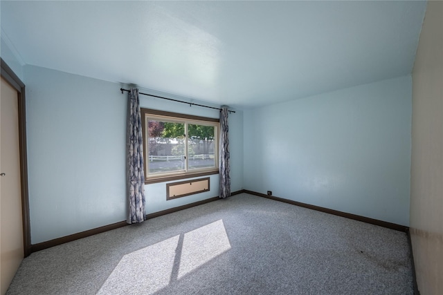 spare room featuring carpet flooring and baseboards
