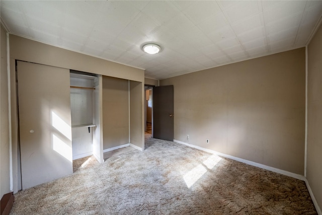 unfurnished bedroom featuring baseboards, a closet, and light colored carpet