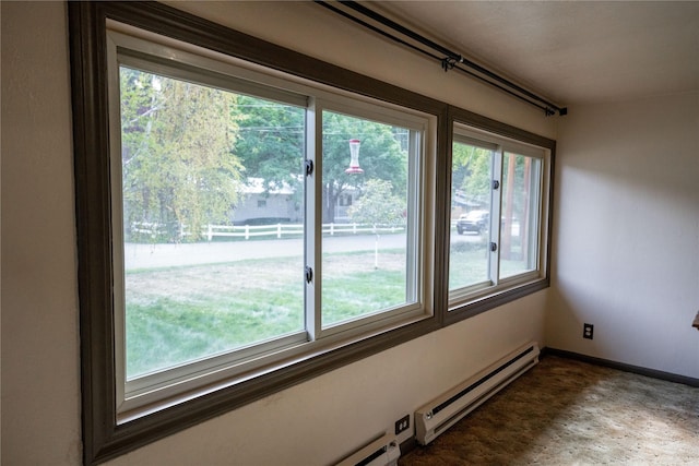 spare room with a baseboard heating unit, baseboards, and plenty of natural light