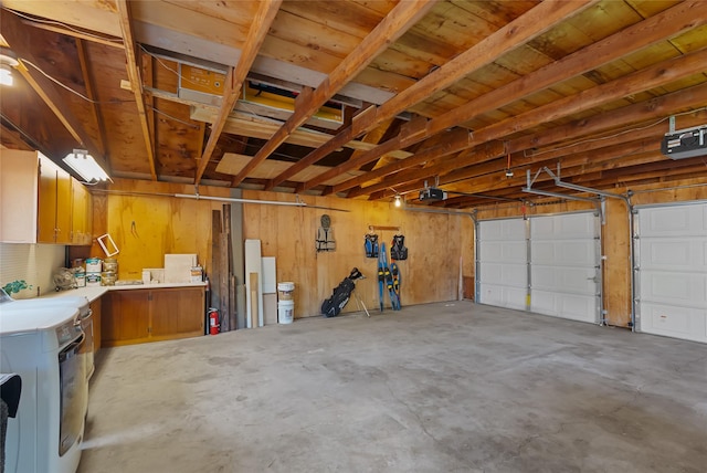 908 10th St, Whitefish, MT 59937 - garage featuring washer / clothes dryer, a garage door opener, and wooden walls