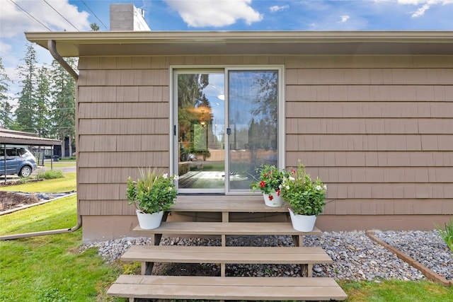 908 10th St, Whitefish, MT 59937 - view of exterior entry featuring a chimney and a lawn