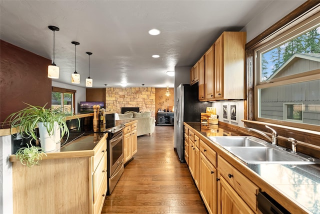908 10th St, Whitefish, MT 59937 - kitchen with open floor plan, wood finished floors, pendant lighting, recessed lighting, and a stone fireplace