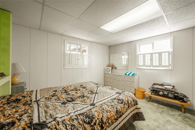 carpeted bedroom featuring a drop ceiling