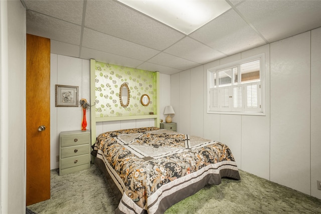 bedroom with a drop ceiling and carpet