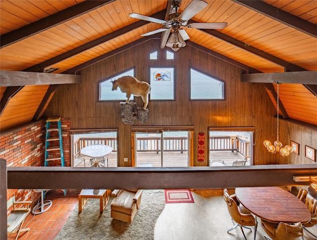 interior space featuring wood walls, a notable chandelier, wooden ceiling, and lofted ceiling with beams