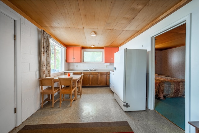 kitchen with wooden ceiling, white refrigerator, and sink