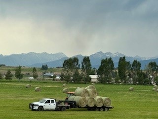 view of property's community with a lawn, a rural view, and a mountain view