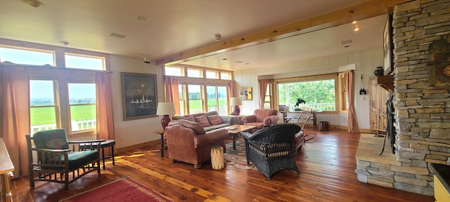 living room with dark hardwood / wood-style floors, beam ceiling, and a fireplace