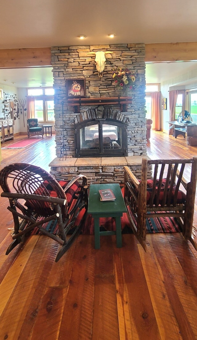 living room featuring a fireplace, hardwood / wood-style flooring, and a healthy amount of sunlight