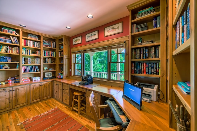 office with built in desk and hardwood / wood-style floors